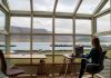 Why Top Executives Are Trading Boardrooms for Remote Luxury Workations person in blue jacket sitting on brown wooden chair near brown wooden table during daytime