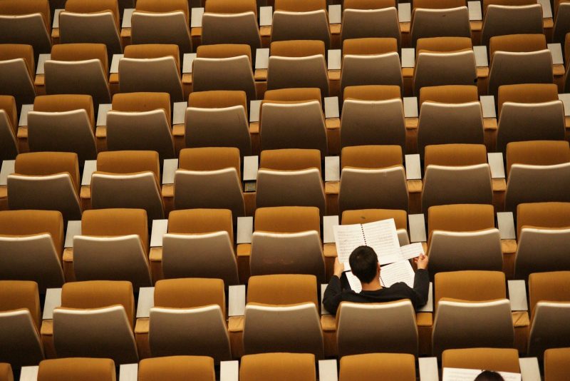 Photo by Philippe Bout person reading in empty lecture hall