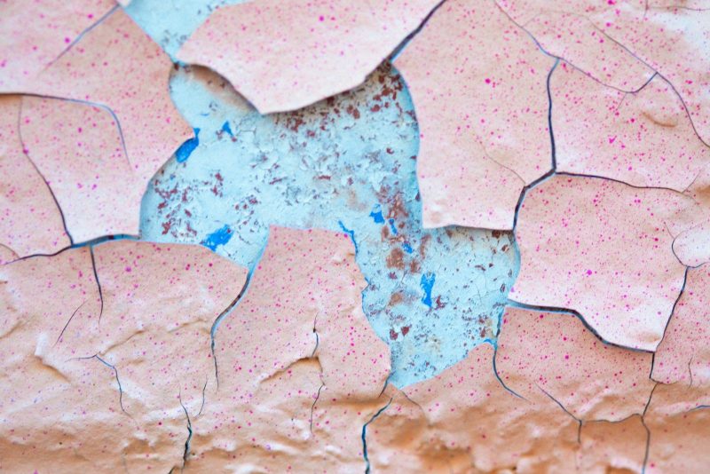 Photo by Benoit Roy A close up of a piece of paper with paint peeling off of it