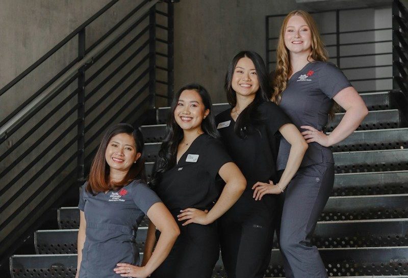 Photo by Andrew Rivera a group of women standing on top of a set of stairs