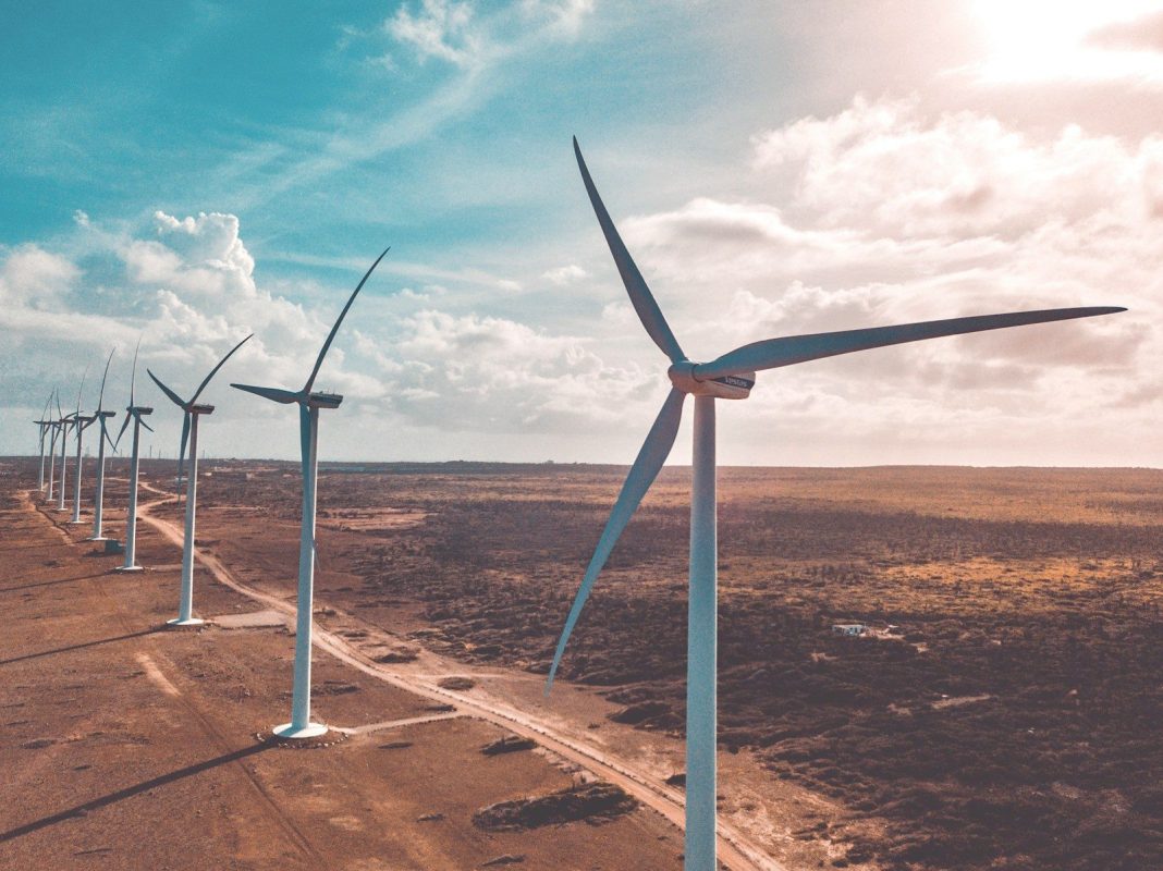 Photo by Rabih Shasha wind turbines on brown sand under white clouds and blue sky during daytime