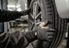 Beyond the Headline Price: What Should a Tyre Fitting Quote Include? a man working on a tire in a garage