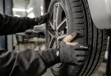 Beyond the Headline Price: What Should a Tyre Fitting Quote Include? a man working on a tire in a garage