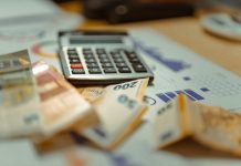 The RSU Vesting Date Nobody Calendared: Why Employees Keep Owing Tax on Stock They Never Sold A calculator sitting on top of a pile of money